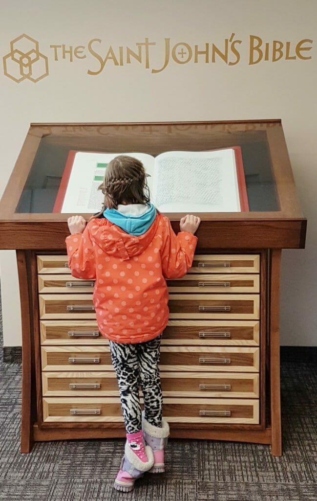 <em>The Saint John's Bible</em> engages all ages, like this young appreciator at the Diocese of Hamilton in Ontario.