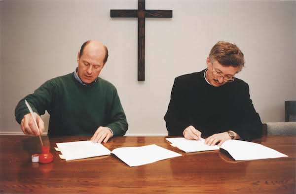 Donald Jackson (left) and the late Brother Dietrich Rienhart, OSB (right) sign the commission of The Saint John's Bible.