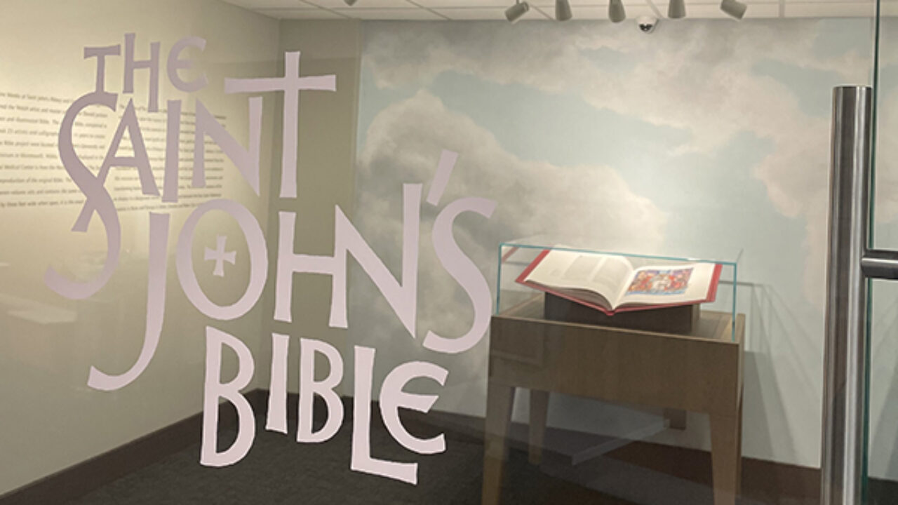 The Saint John's Bible is opened up behind a glass wall