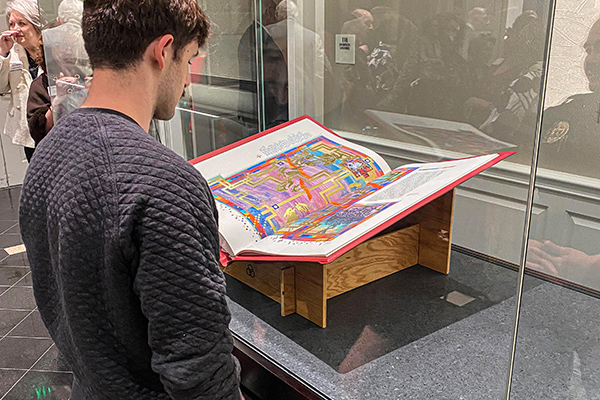 Visitors admire The Saint John's Bible behind a glass case