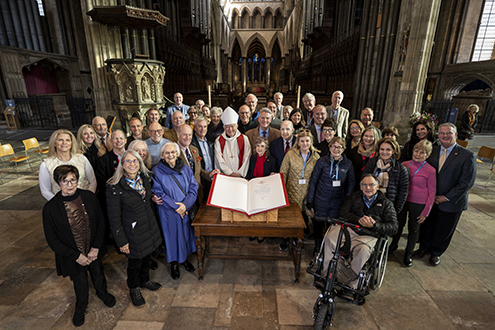 Photo: The entire Dedication Tour group poses for a photo at Salisbury Cathedral in front of a Heritage Edition. Dan Whalen is pictured to the left of the Bishop of Salisbury, the Most Reverend Stephen Lake. 
