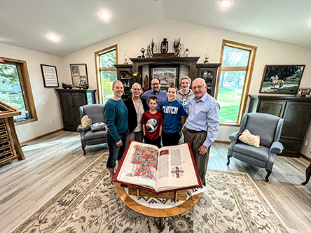 Photo: A family stands by one Heritage Edition volume in their home. 