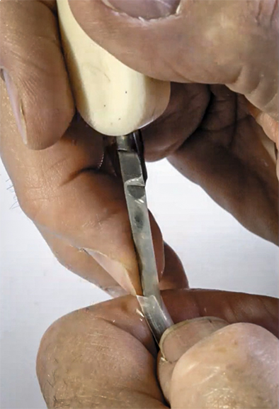 The scribe takes his pen knife and carefully cuts down the center of the tip, creating a slit (8:45).