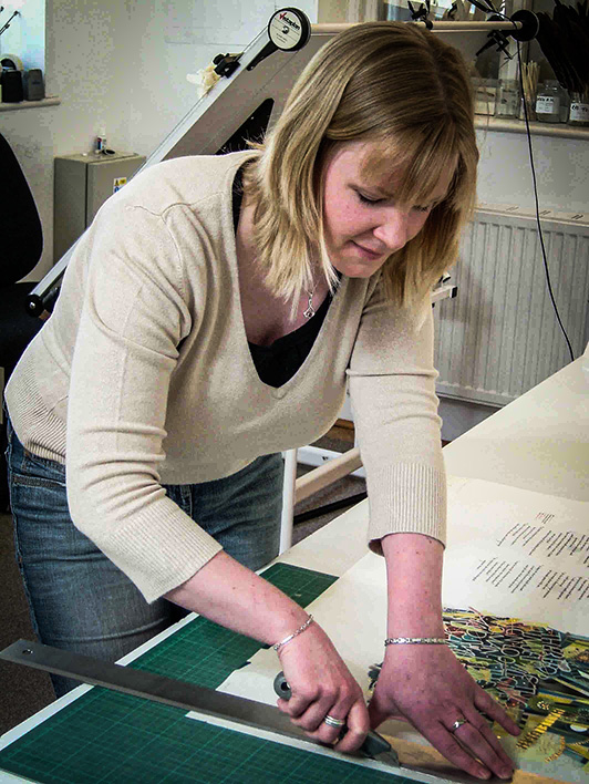 Sarah Harris trims finished vellum pages of The Saint John’s Bible in the Wales scriptorium.