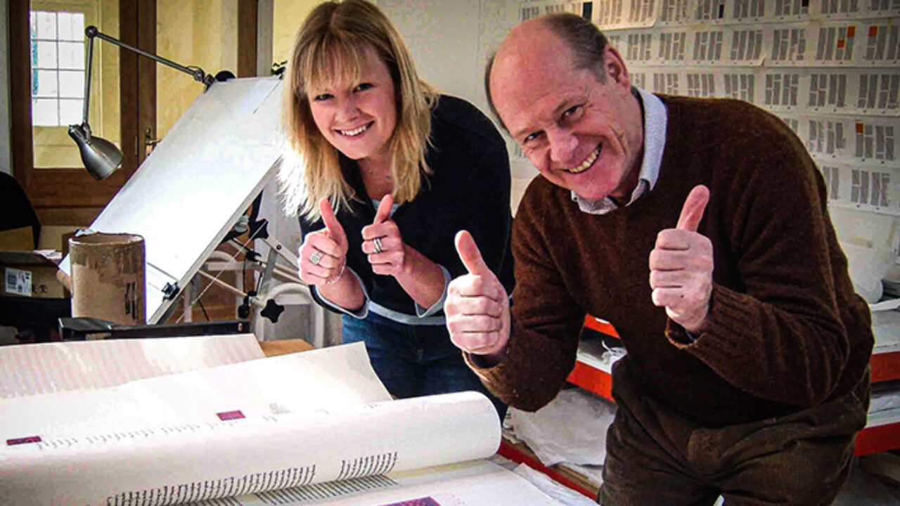 Sarah Harris and Donald Jackson unwrap an illumination by calligrapher Hazel Dolby.