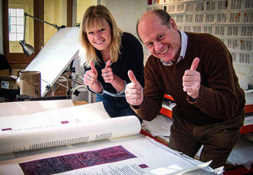 Sarah Harris and Donald Jackson unwrap an illumination by calligrapher Hazel Dolby.