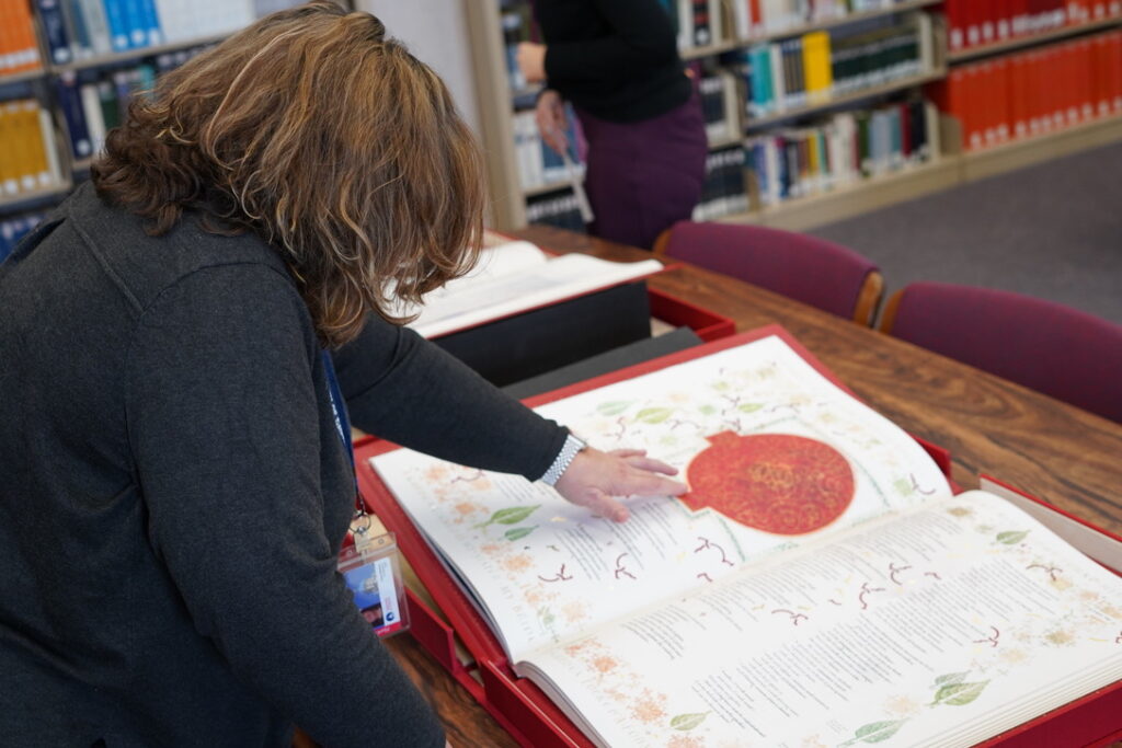 Two people look at one page of The Saint John's Bible Heritage Edition