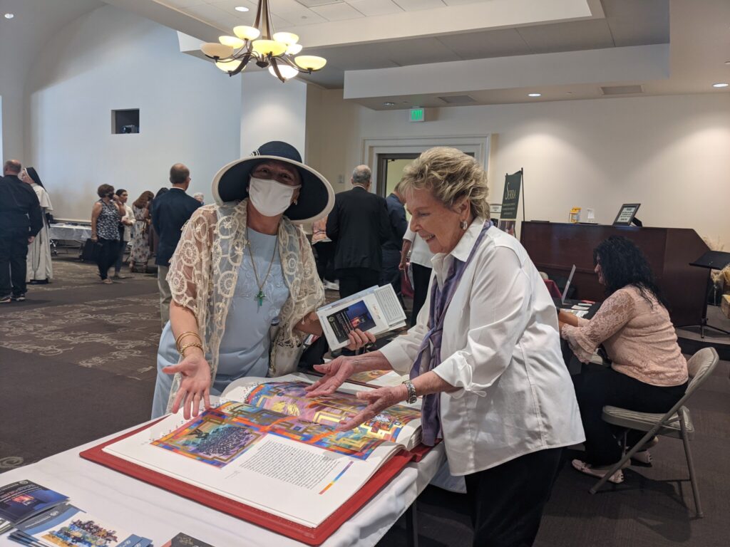 Two people look at one page of The Saint John's Bible Heritage Edition