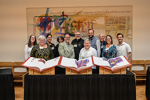 St. Olaf College faculty and staff pose with The Saint John’s Bible Heritage Edition on the day they collectively brought it from Collegeville, Minnesota, to St. Olaf College in Northfield, Minnesota. 